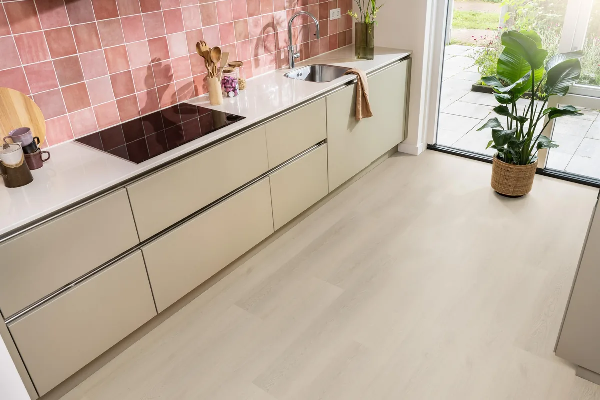 Merton / Navaro beige, plak pvc in een keuken met een roze tegelwand en openslaande tuindeuren