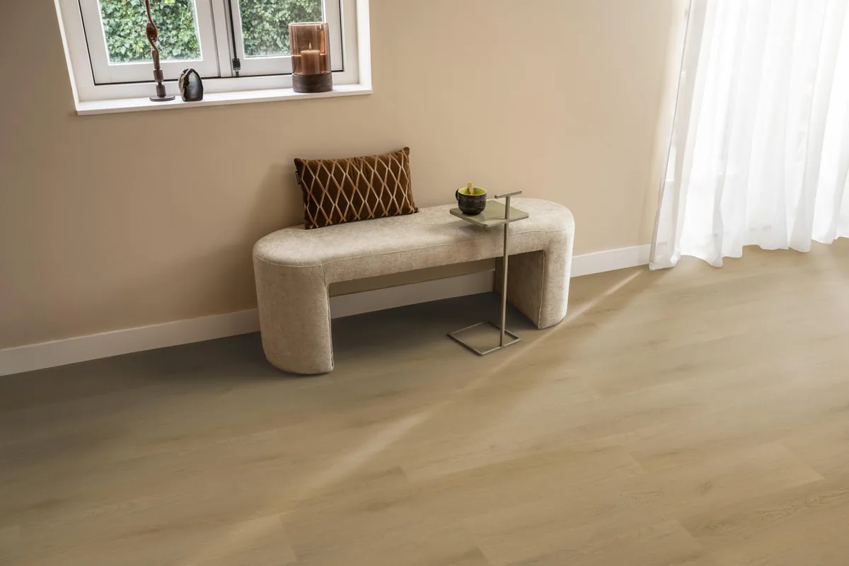 Merton / Navaro light oak, klik pvc in een hal, met een bankje onder het raam en zonlicht over de vloer
