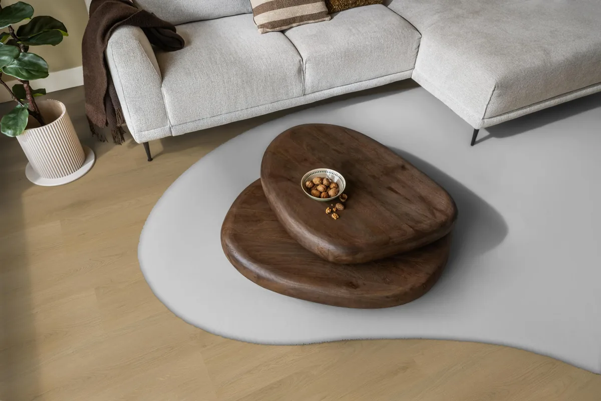 Merton / Navaro light oak, klik pvc in een woonkamer, met een lichte hoekbank en een wit vloerkleed