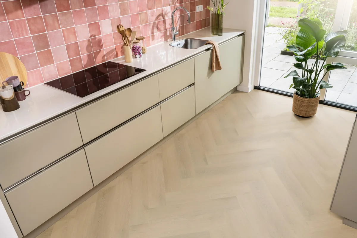 Merton / Navaro Light oak, visgraat klik pvc in een keuken met een roze tegelwand en openslaande tuindeuren