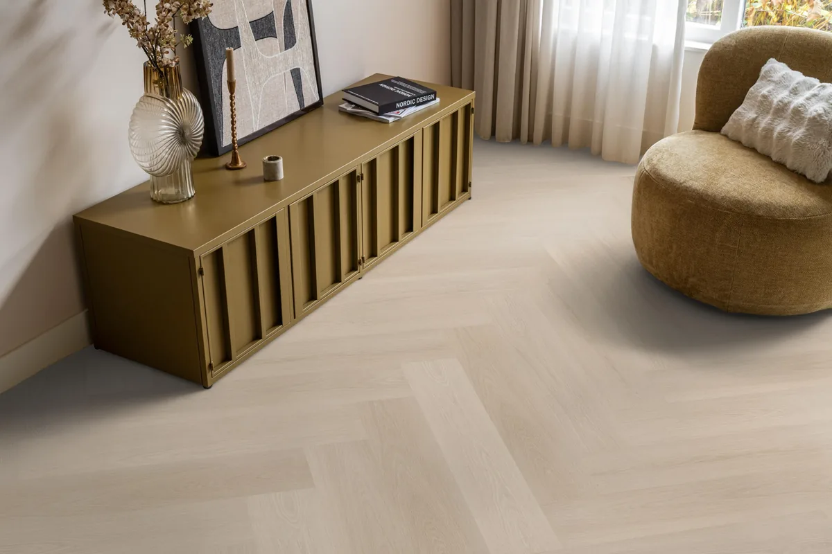 Brentford / Soleno Beige, visgraat klik pvc in een woonkamer, met een okergeel dressoir en een ronde fauteuil