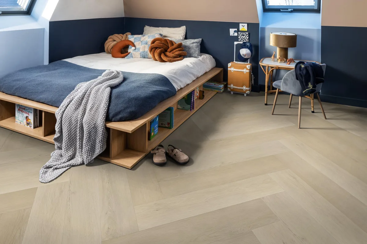 Mayfair / Marento beige, EVC-vloer in een slaapkamer onder een schuin dak, met een houten bedombouw en sloffen ervoor