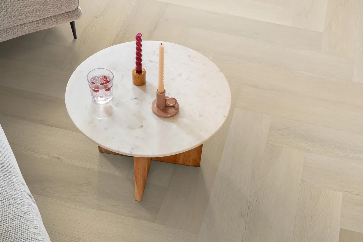 Mayfair / Marento beige, EVC-vloer in een woonkamer, met een ronde marmeren salontafel en twee kaarsen