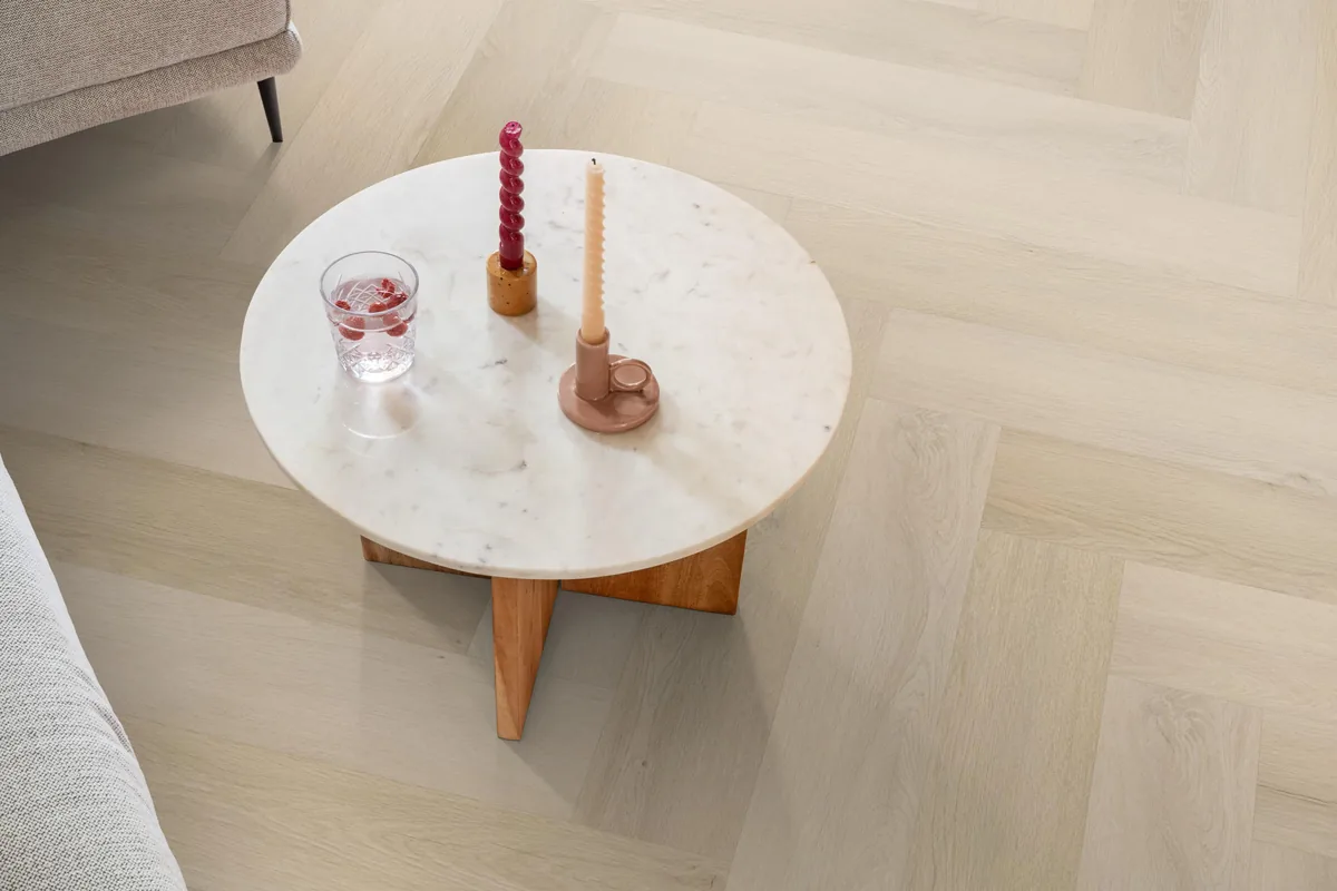 Mayfair / Marento Natural, EVC-vloer in een woonkamer, met een ronde marmeren salontafel en twee kaarsen