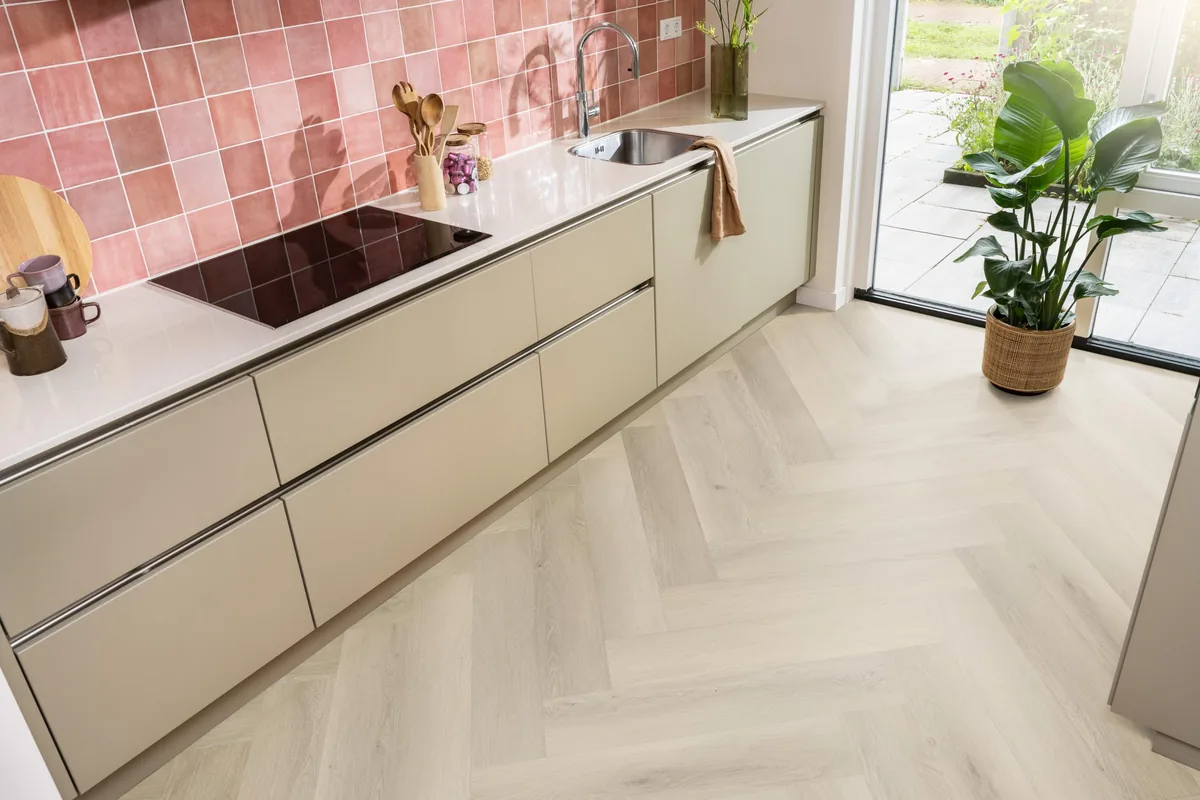 Mayfair / Marento Warm oak, EVC-vloer in een keuken met een roze tegelwand en openslaande tuindeuren