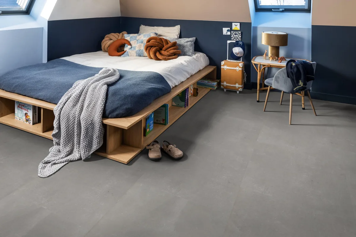 Westminster / Piero light grey, klik pvc in een slaapkamer onder een schuin dak, met een houten bedombouw en sloffen ervoor