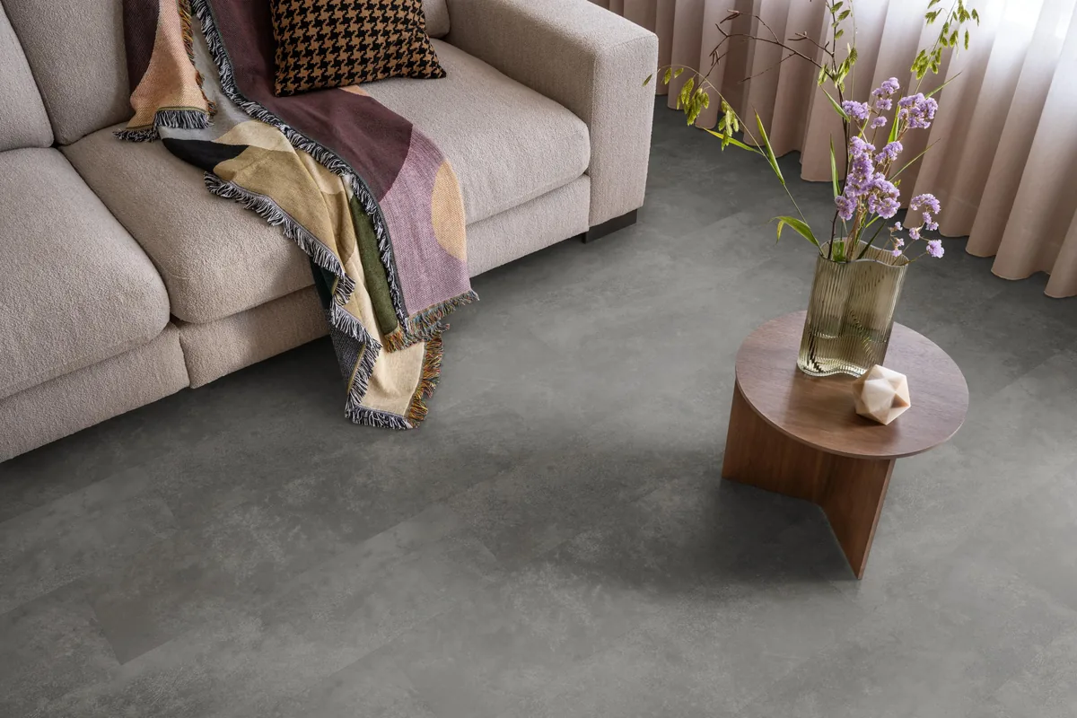 Finsbury / Viretto Grey, plak pvc in een woonkamer, met een beige bank en een ronde bijzettafel met bloemen