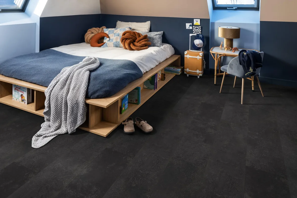 Finsbury / Viretto Anthracite, plak pvc in een slaapkamer onder een schuin dak, met een houten bedombouw en sloffen ervoor