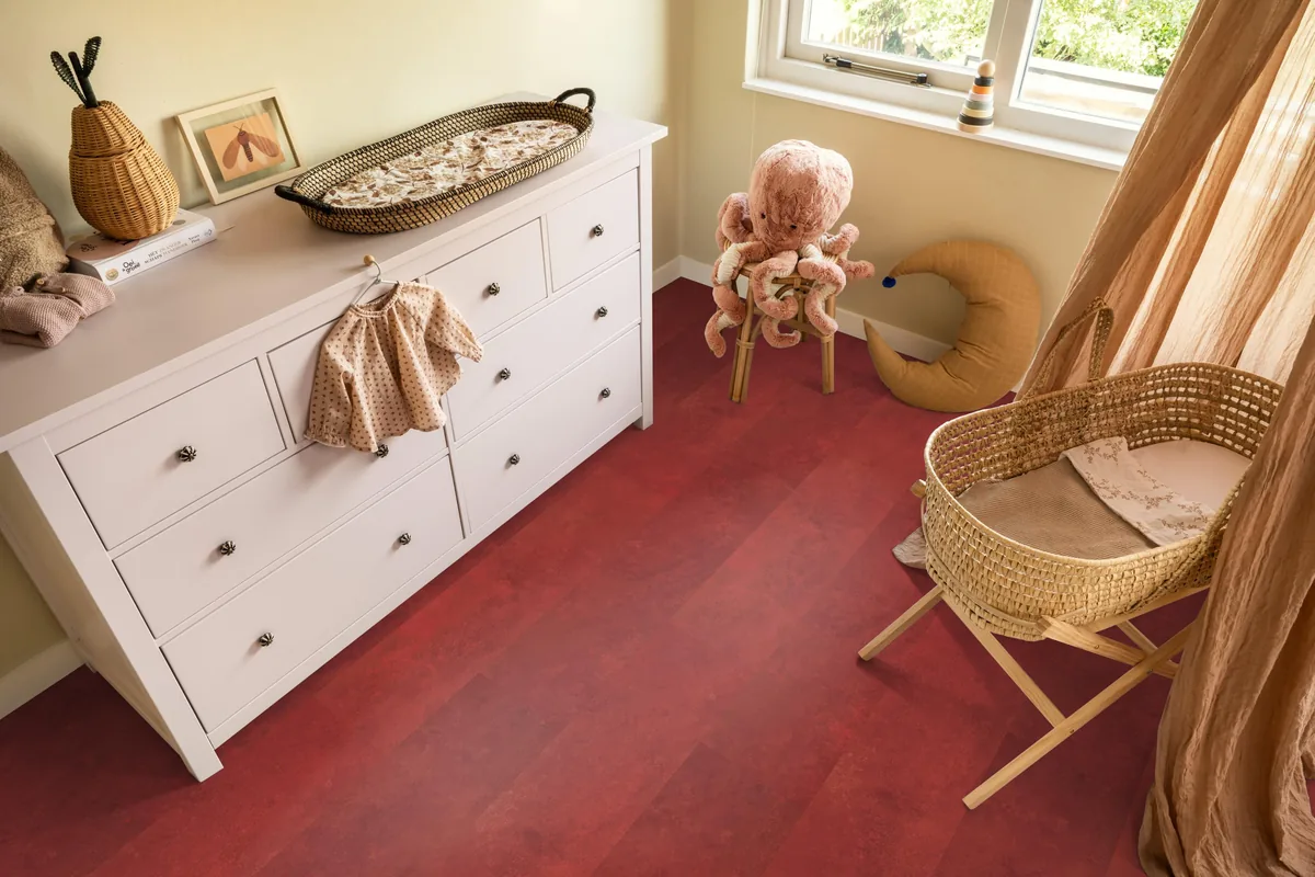 Finsbury / Viretto Red, plak pvc in een babykamer, met een witte commode en een rieten wieg