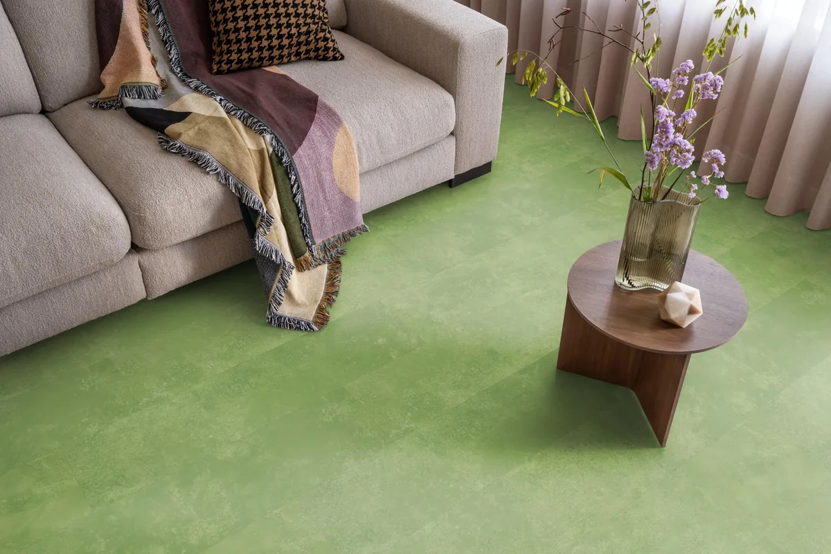 Finsbury / Viretto Green, plak pvc in een woonkamer, met een beige bank en een ronde bijzettafel met bloemen