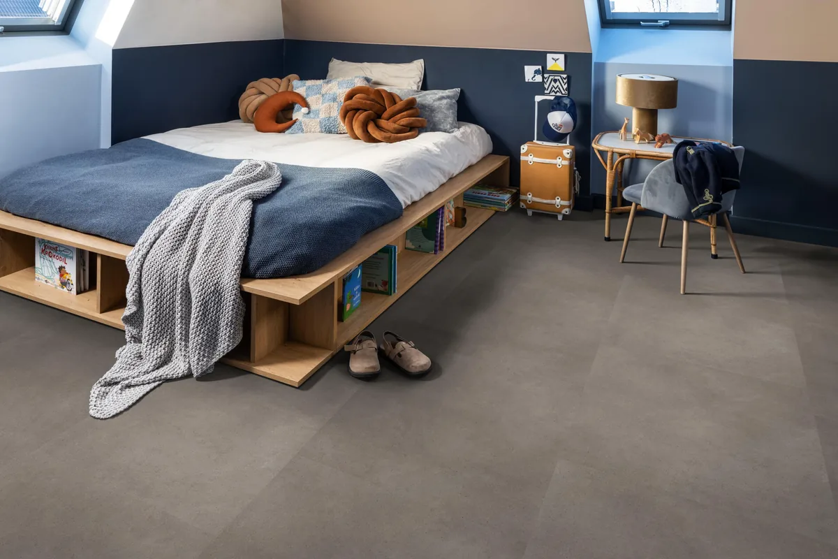 Peckham / Baroso taupe, klik pvc in een slaapkamer onder een schuin dak, met een houten bedombouw en sloffen ervoor
