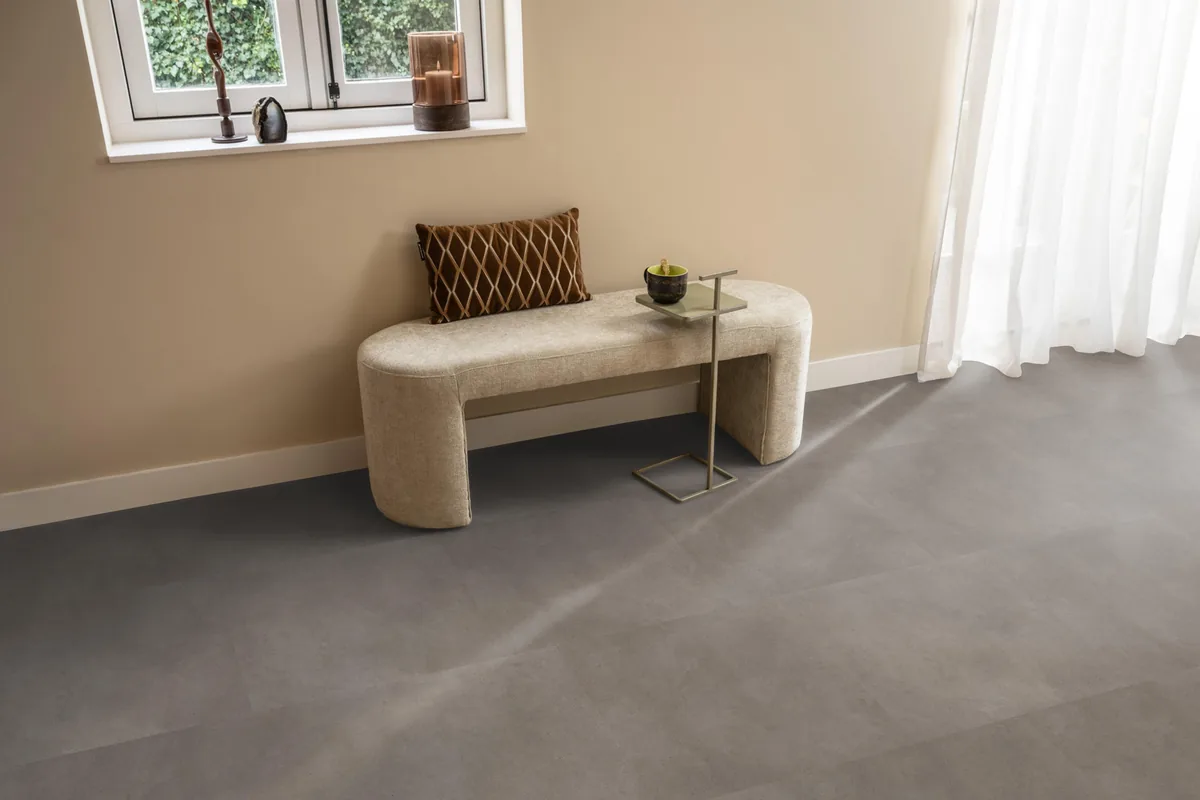 Peckham / Baroso taupe, klik pvc in een hal, met een bankje onder het raam en zonlicht over de vloer