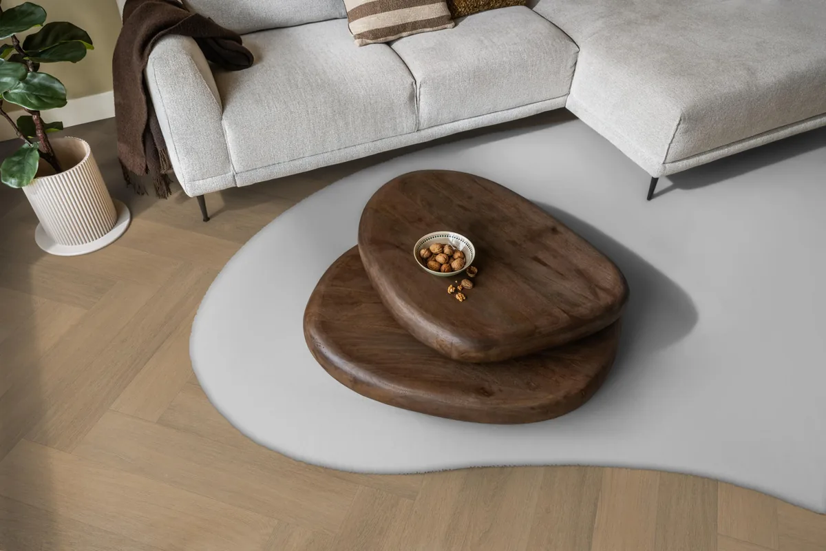 Sutton / Viranto warm natural, visgraat plak pvc in een woonkamer, met een lichte hoekbank en een wit vloerkleed