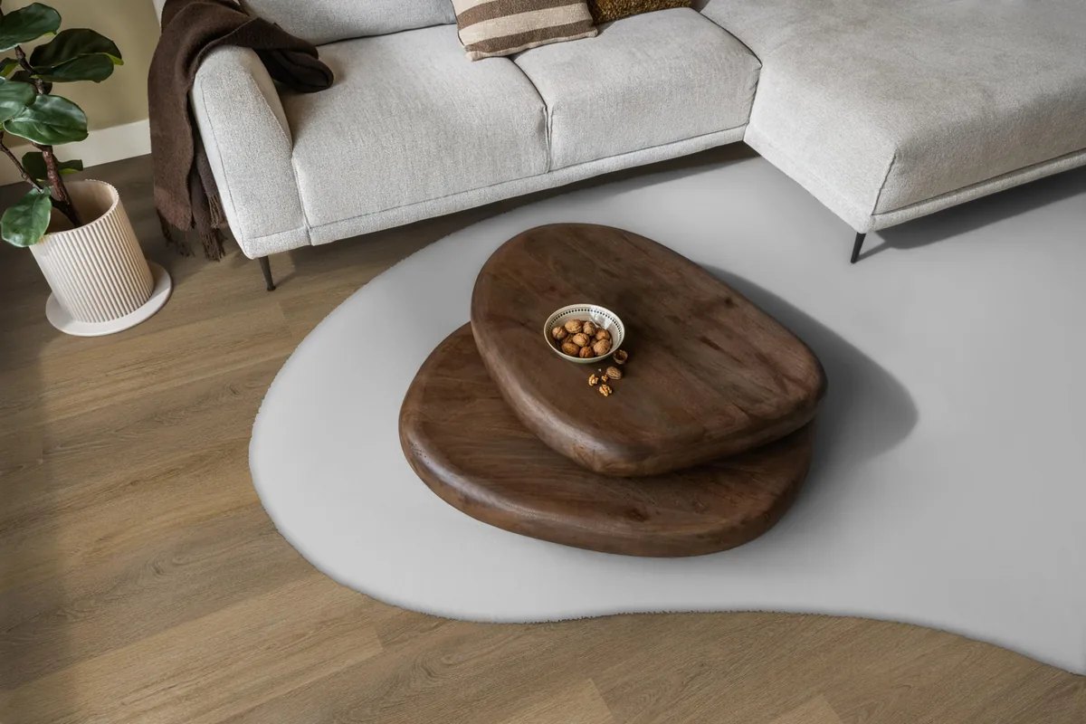 Sutton / Viranto Light brown, klik pvc in een woonkamer, met een lichte hoekbank en een wit vloerkleed