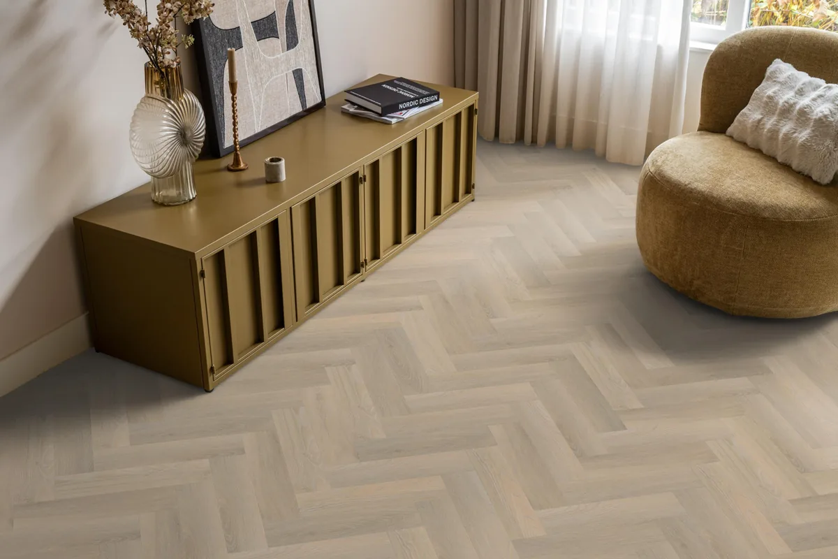 YUP / Spigato small beige, visgraat plak pvc in een woonkamer, met een okergeel dressoir en een ronde fauteuil