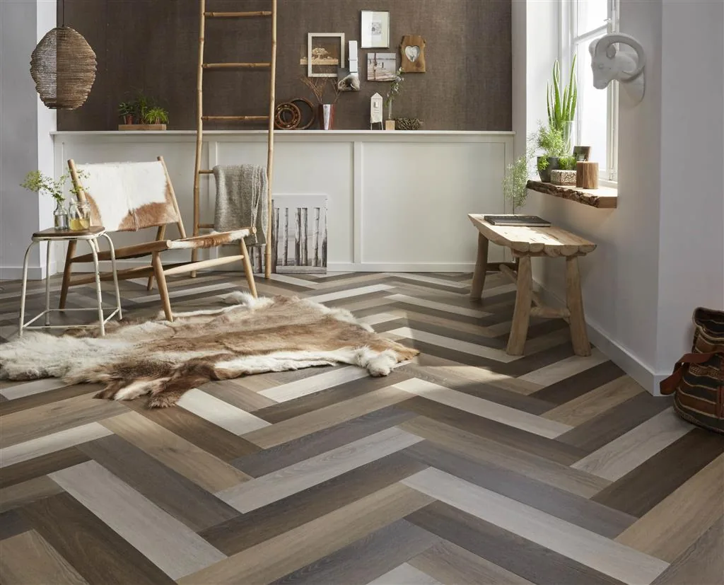 YUP / Spigato light brown, visgraat plak pvc als legvoorbeeld in een hal, met meerdere tinten uit de serie door elkaar gelegd