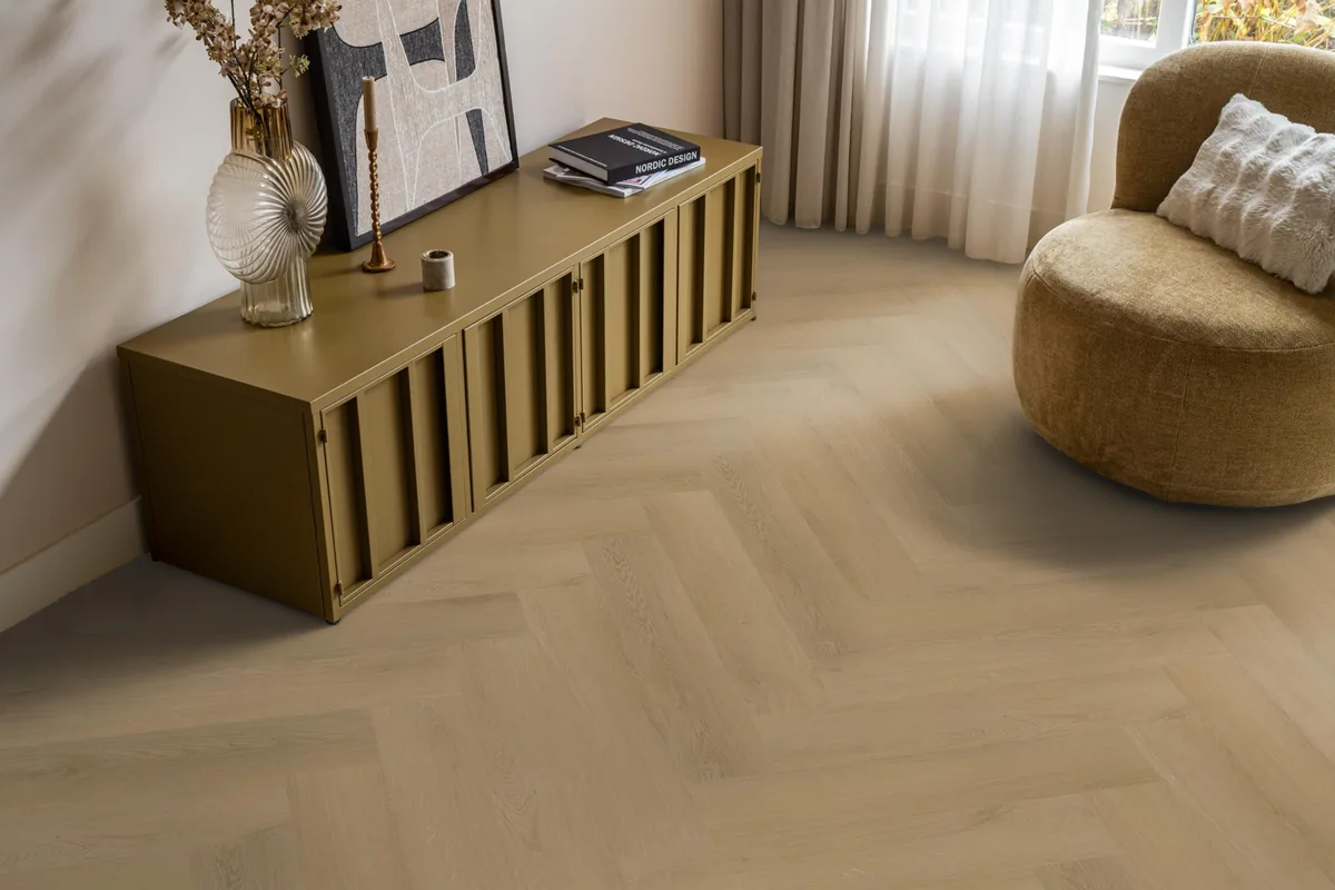 Merton / Navaro light oak, visgraat plak pvc in een woonkamer, met een okergeel dressoir en een ronde fauteuil