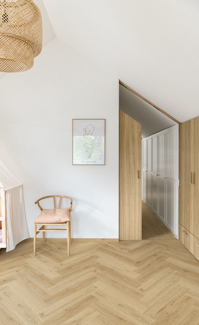 Interieurfoto bij Quick-Step Botanisch beige AVHBU40362: visgraatvloer in een lichte hal met een houten trap.