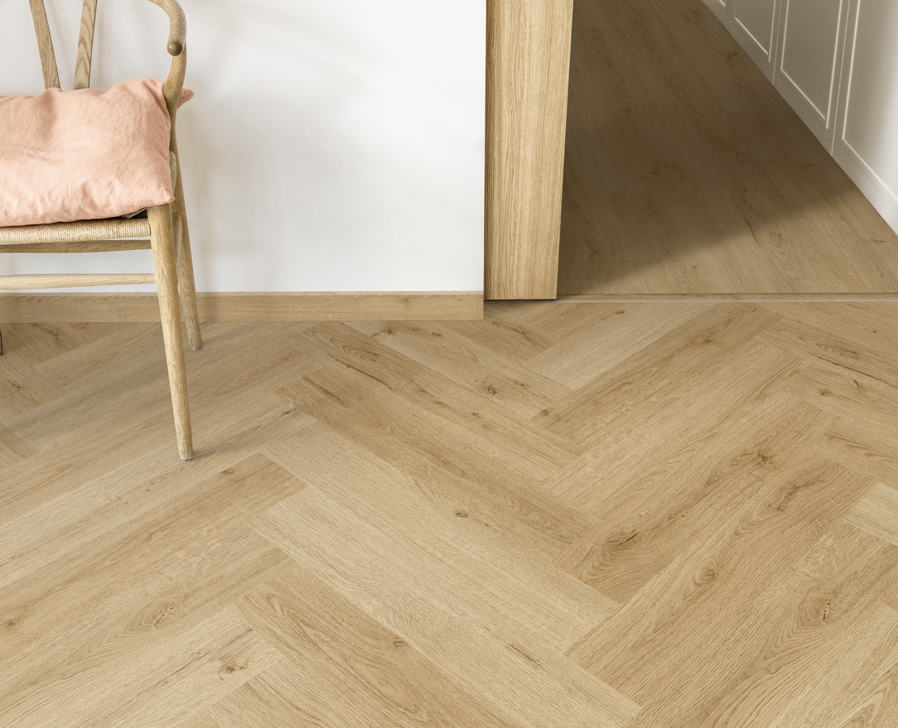 Interieurfoto bij Quick-Step Botanisch beige AVHBU40362: detail van een visgraatvloer met een aangrenzende rechte plankvloer.