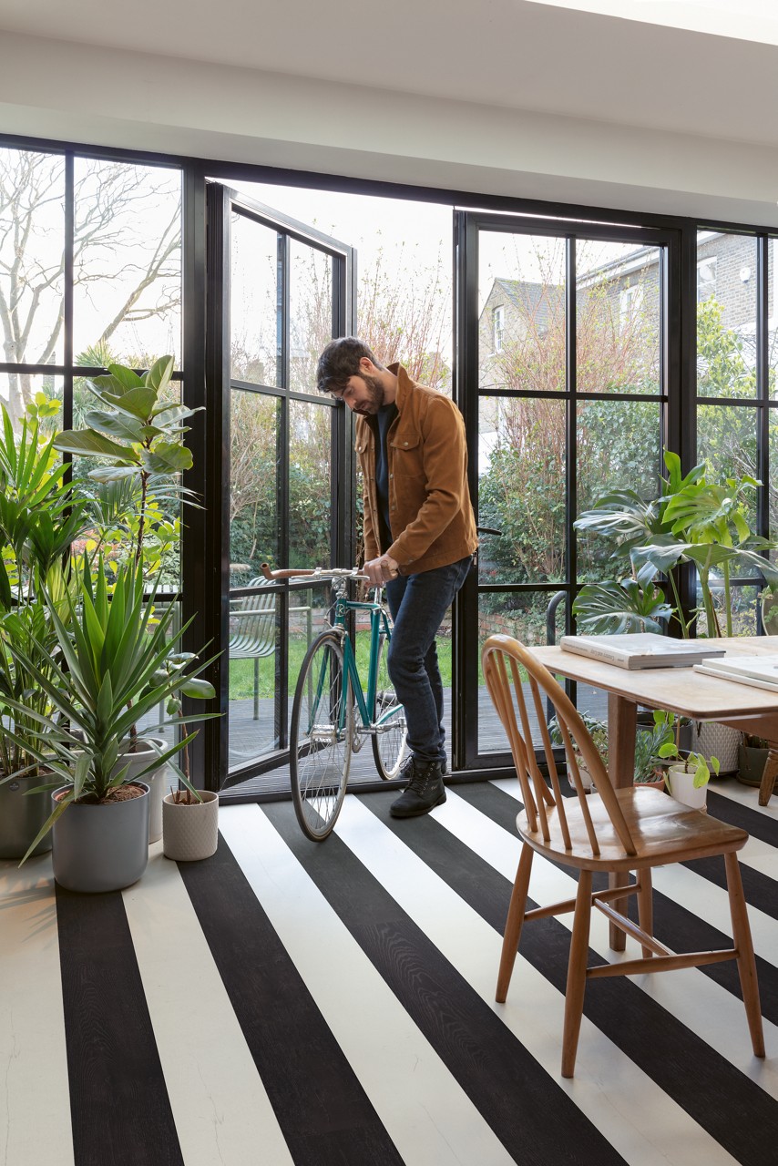 Interieurfoto bij Quick-Step Zwartgeverfde eik SIG4755: interieur met een vloer in afwisselend lichte en zwarte stroken.